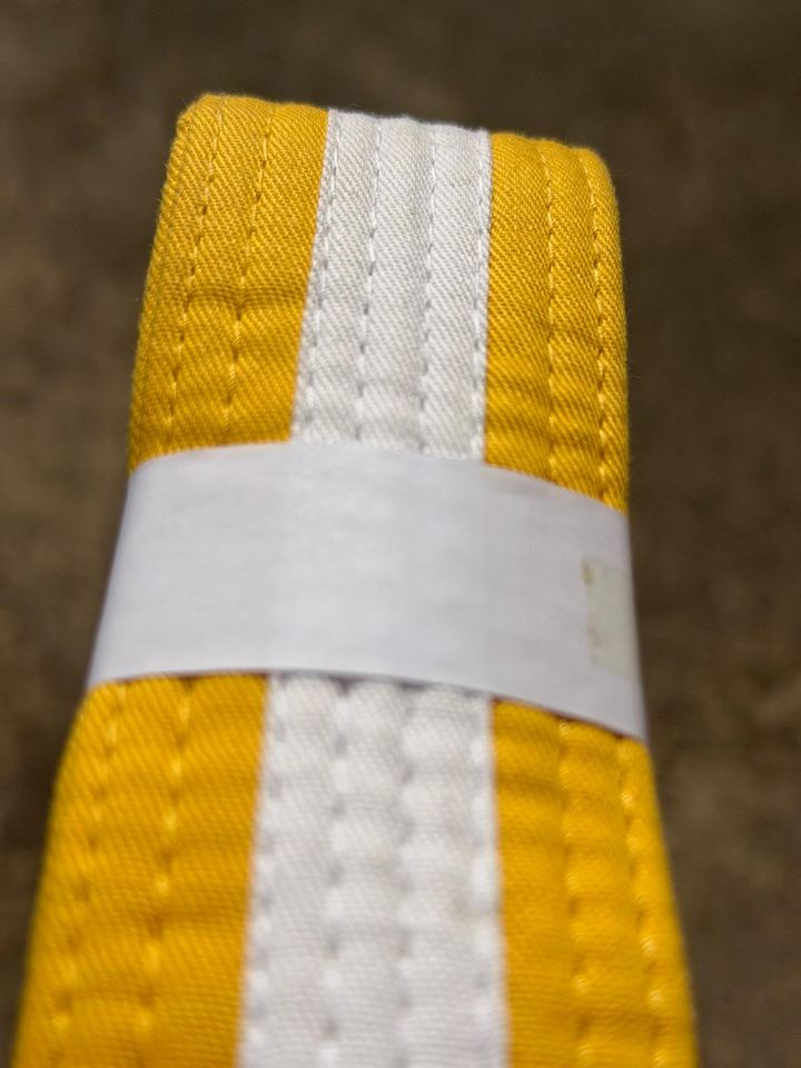 Close-up of a yellow and white BJJ belt