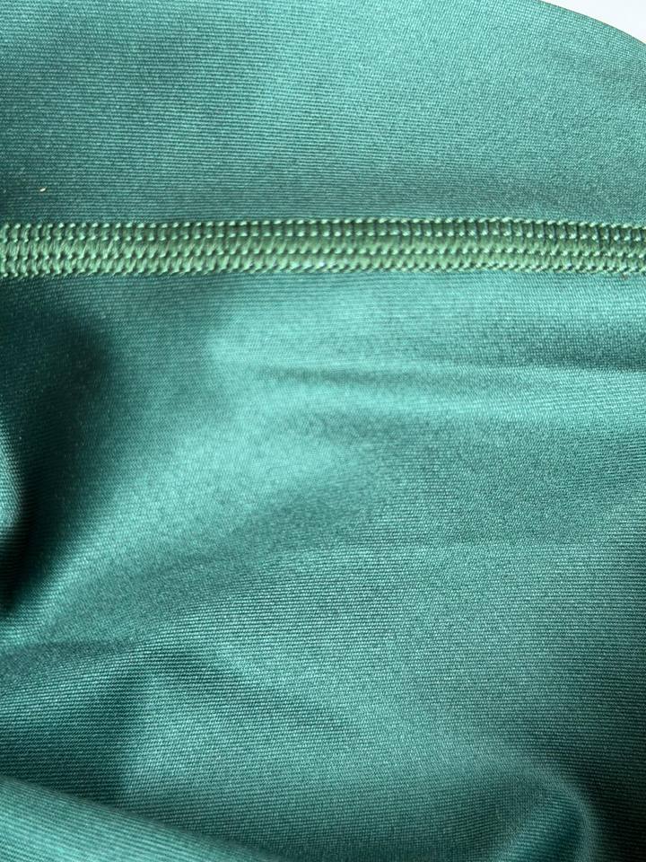Close-up of green rash guard fabric with a flatlock stitched seam